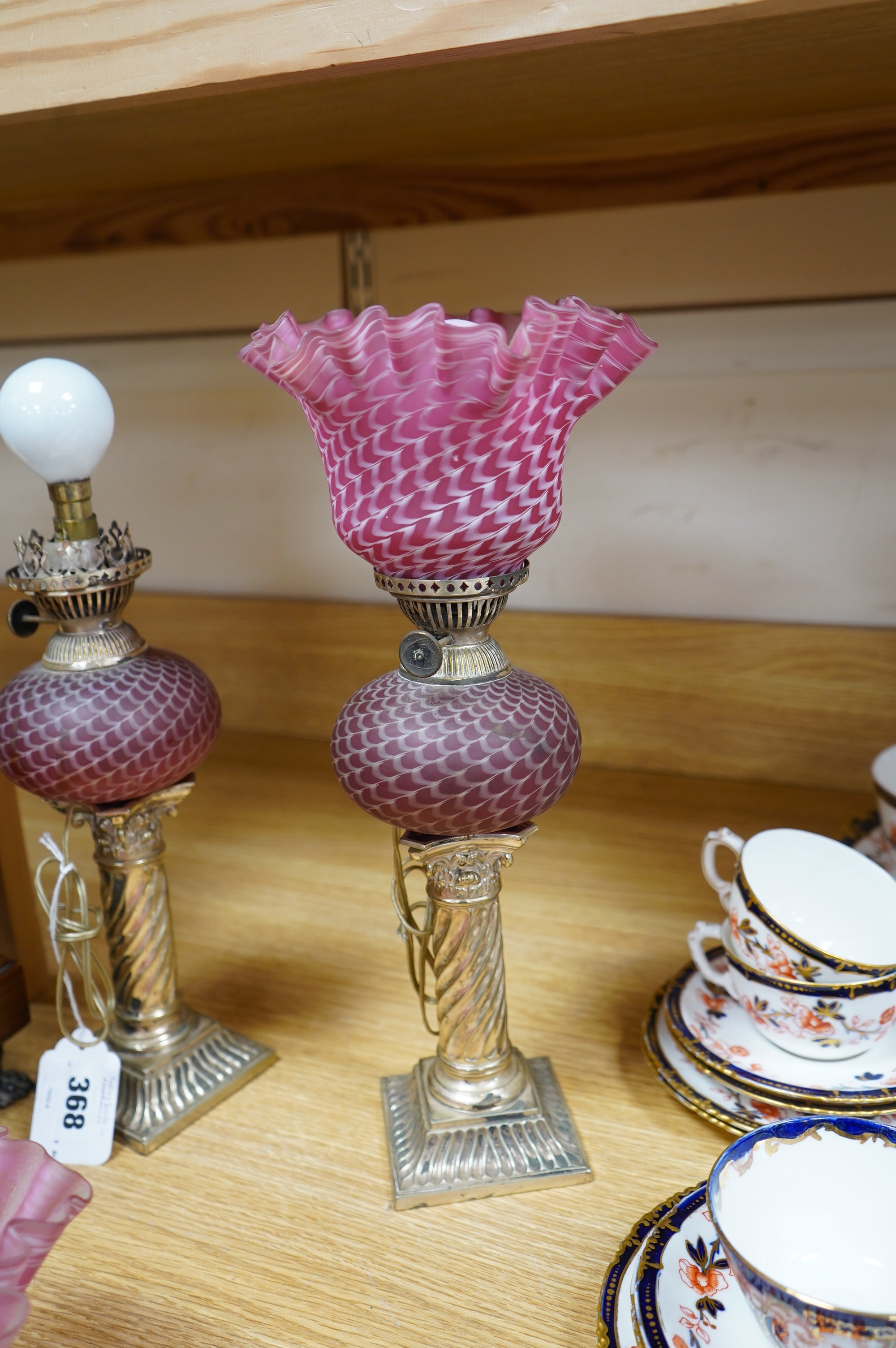 A pair of electroplate and ruby glass oil lamps, 35cm. Condition - good, not tested